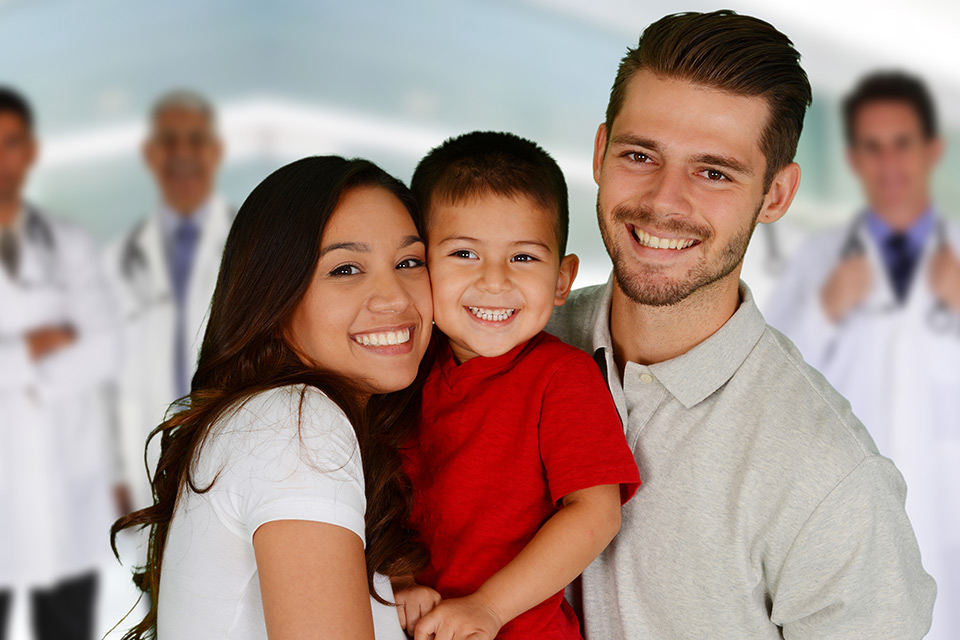 Mother, father and son with healthcare team behind them