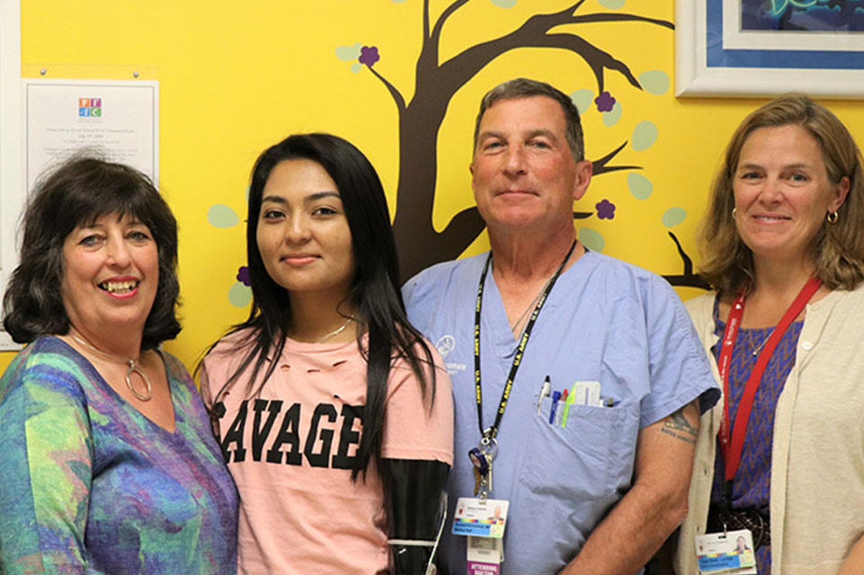 un fournisseur de soirs et une famille prennent la pose avec le patient