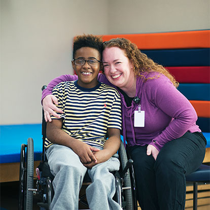 un patient en fauteuil roulant avec un membre du personnel