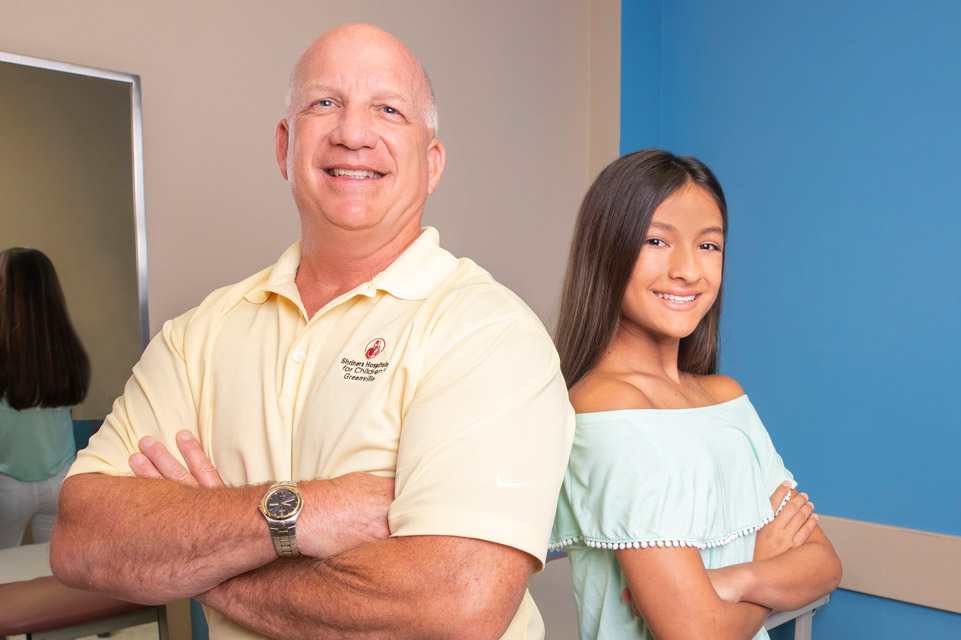 patient and staff member, back to back, smiling