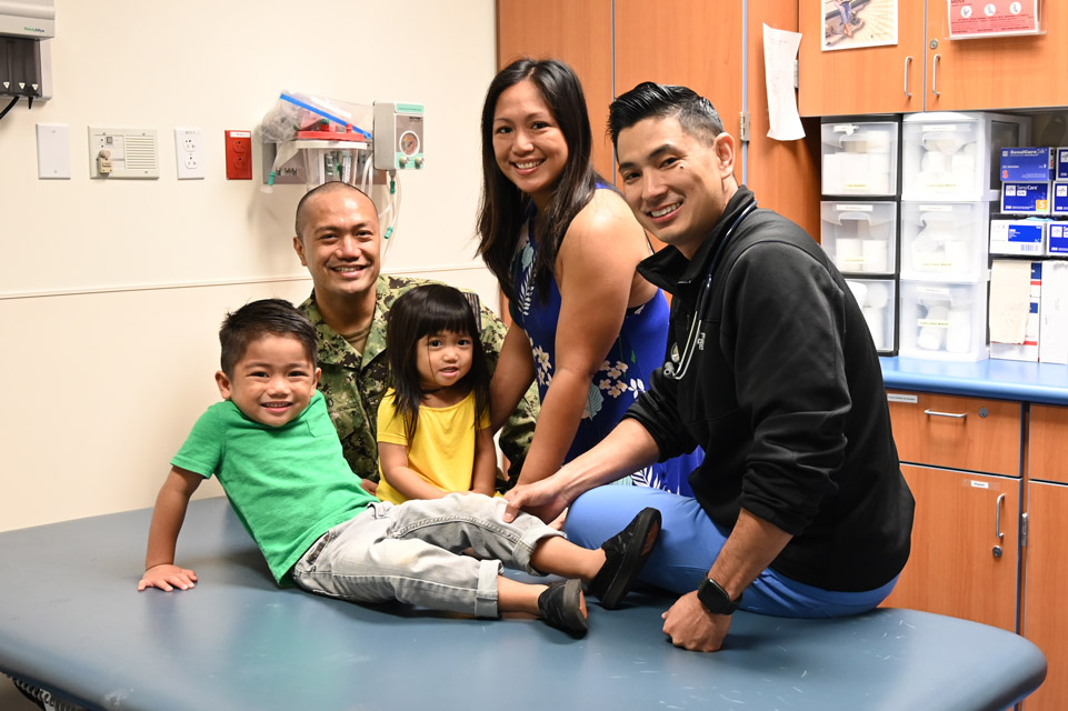 patient on exam table with family and physician