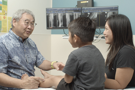 physician speaking with a patient and his mother