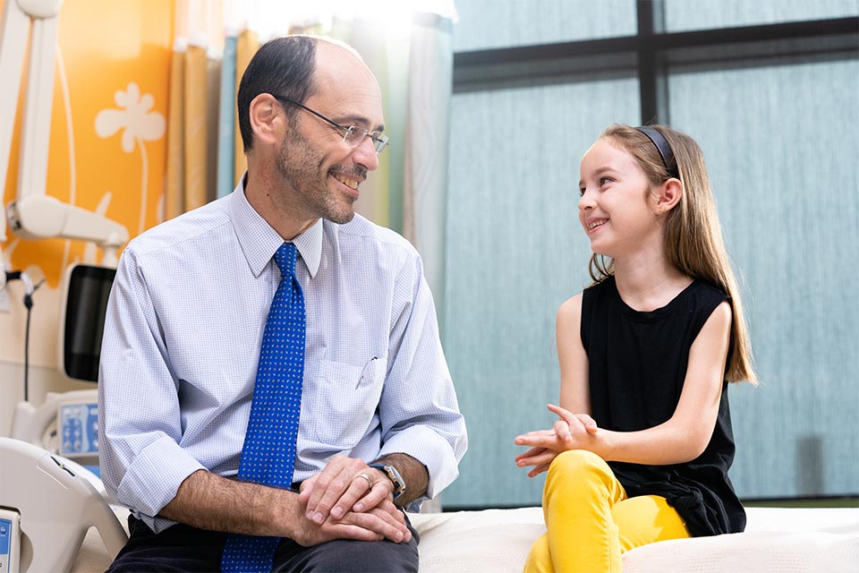 Physician sitting with a female patient smiling