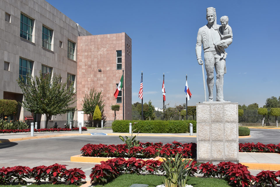 Fachada de la estatua del mensajero silencioso con las banderas de fondo