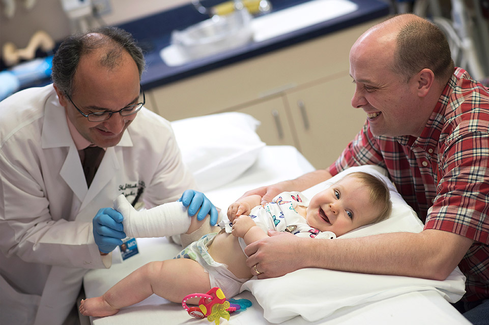 physician, parent and patient during casting procedure