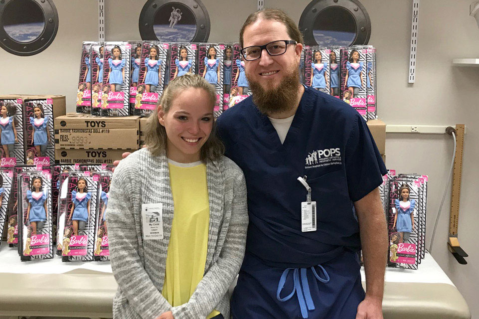 patient and staff member in front of donated toys