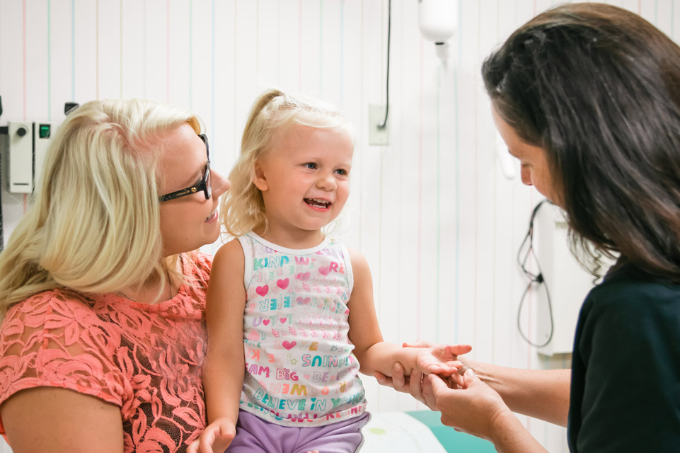 smiling patient with mom and staff member