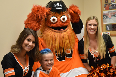 la mascotte du hockey de Philadelphie, les meneuses de claque et le patient