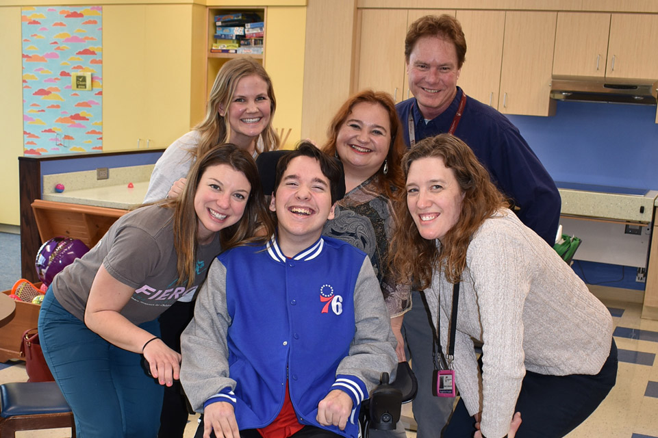 male patient with fours staff members surrounding him