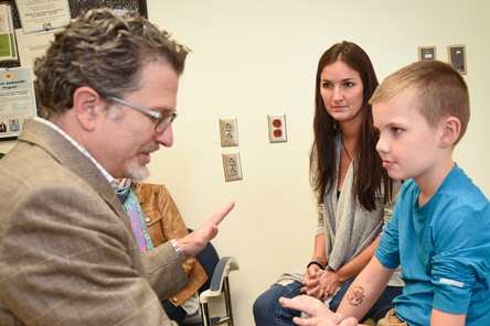 physician examines patient while mother looks on