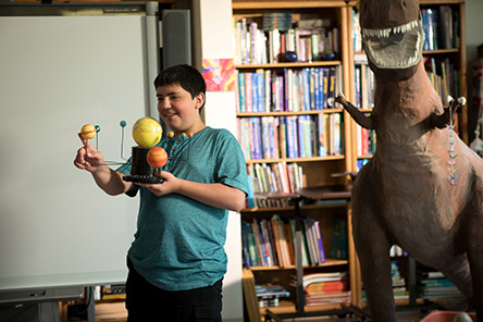 boy holding model of solar system