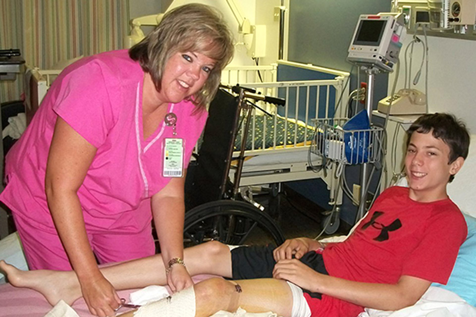 nurse caring for male patient in hospital bed