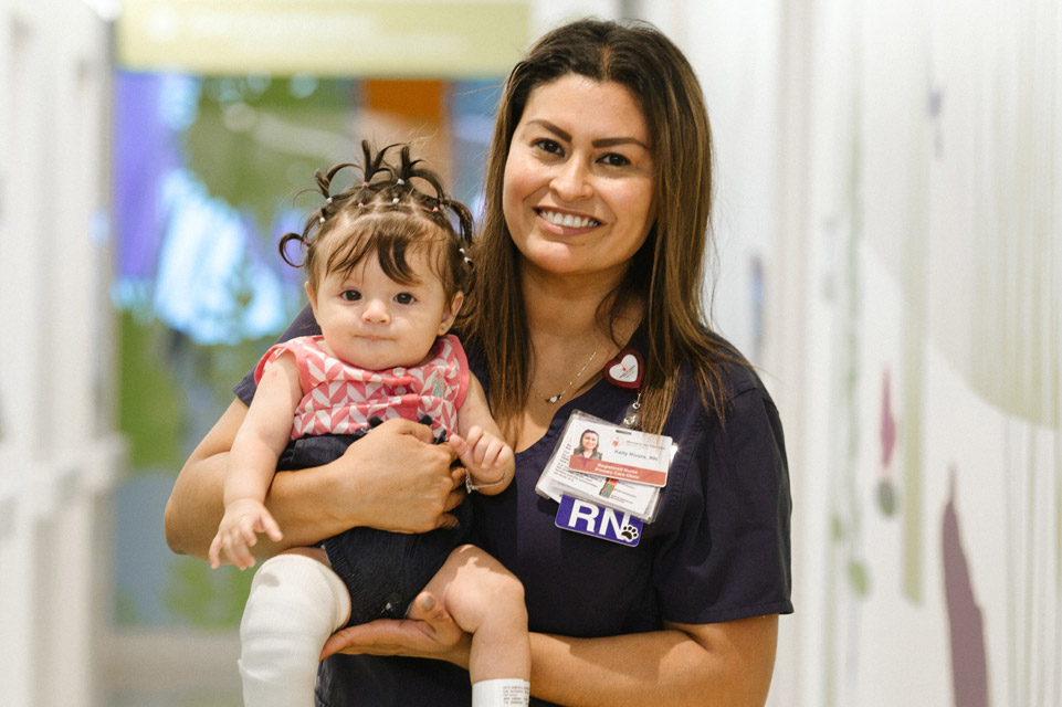 nurse holding young female patient