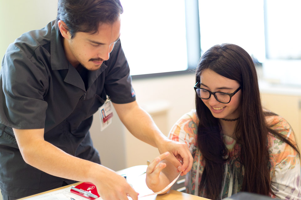 female patient and staff member measuring her hand