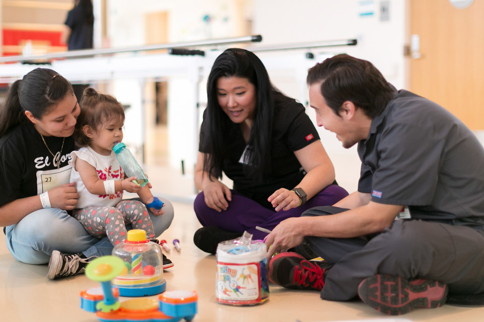 staff members and mom play with patient