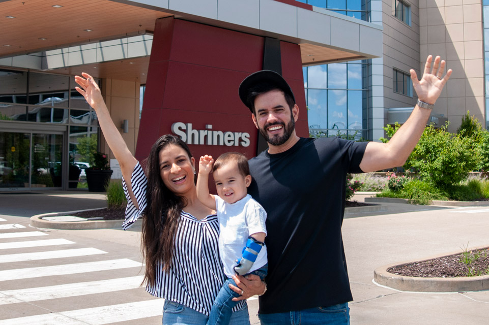 patient with mom and dad in front of hospital building