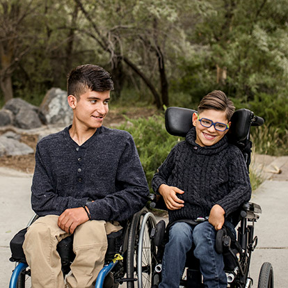 two boys in wheelchairs, outside