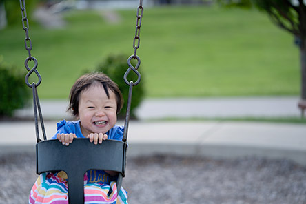 female toddler in swing