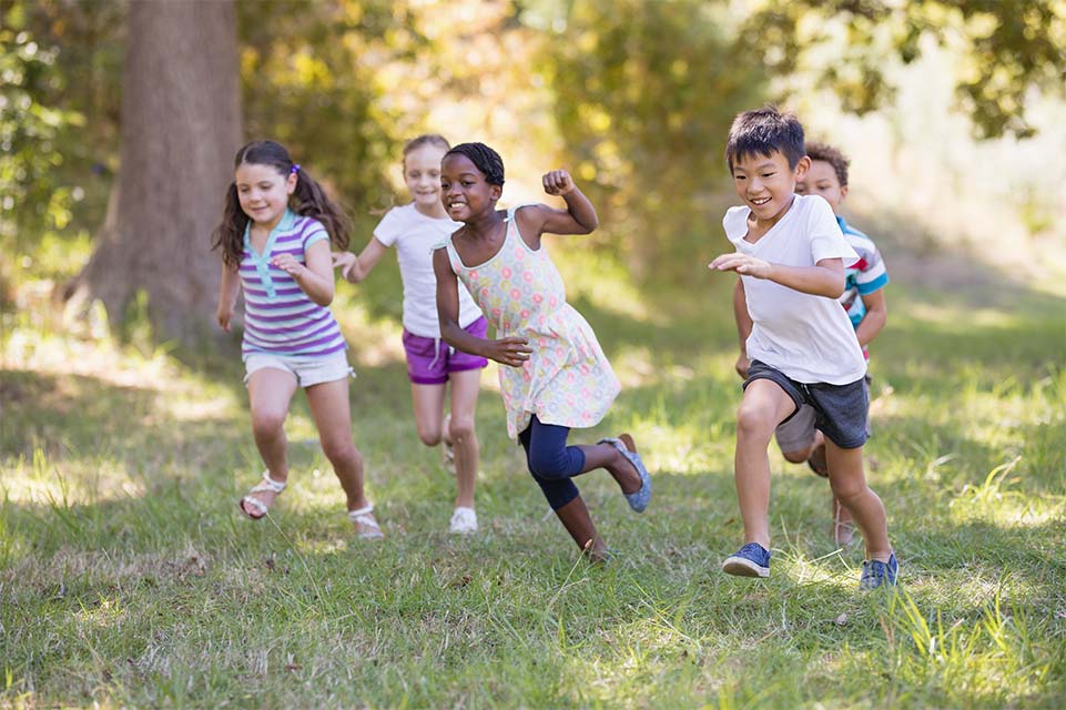 Groupe d’enfants courant dans les bois