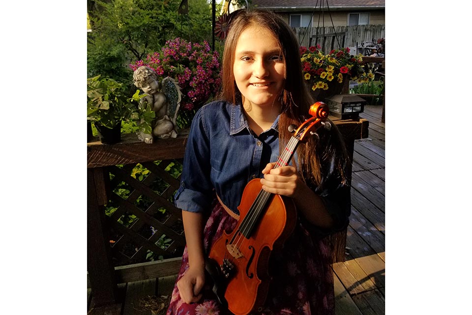 Jasmine holding violin