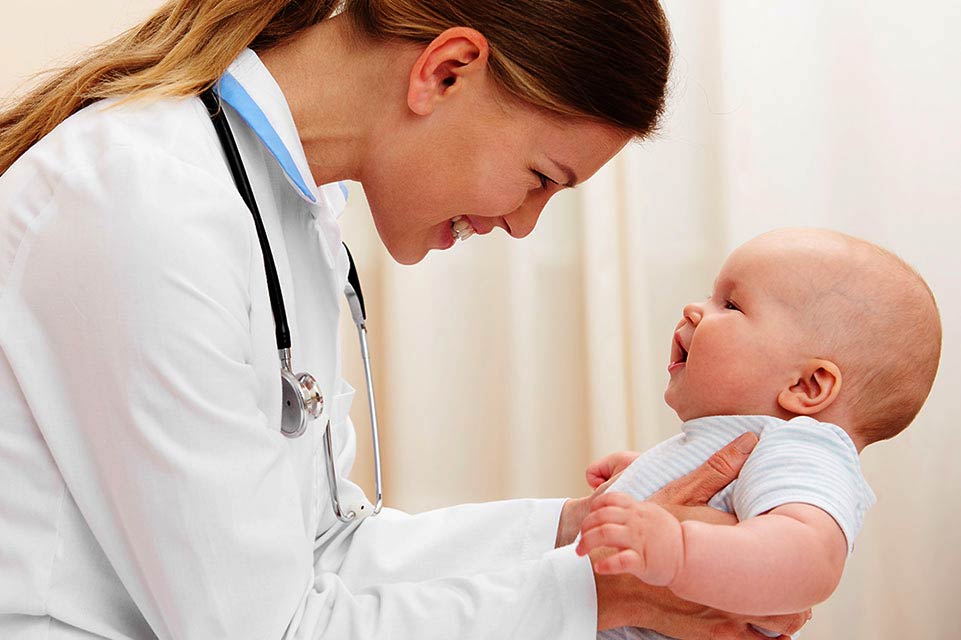 female provider holding infant in clinic