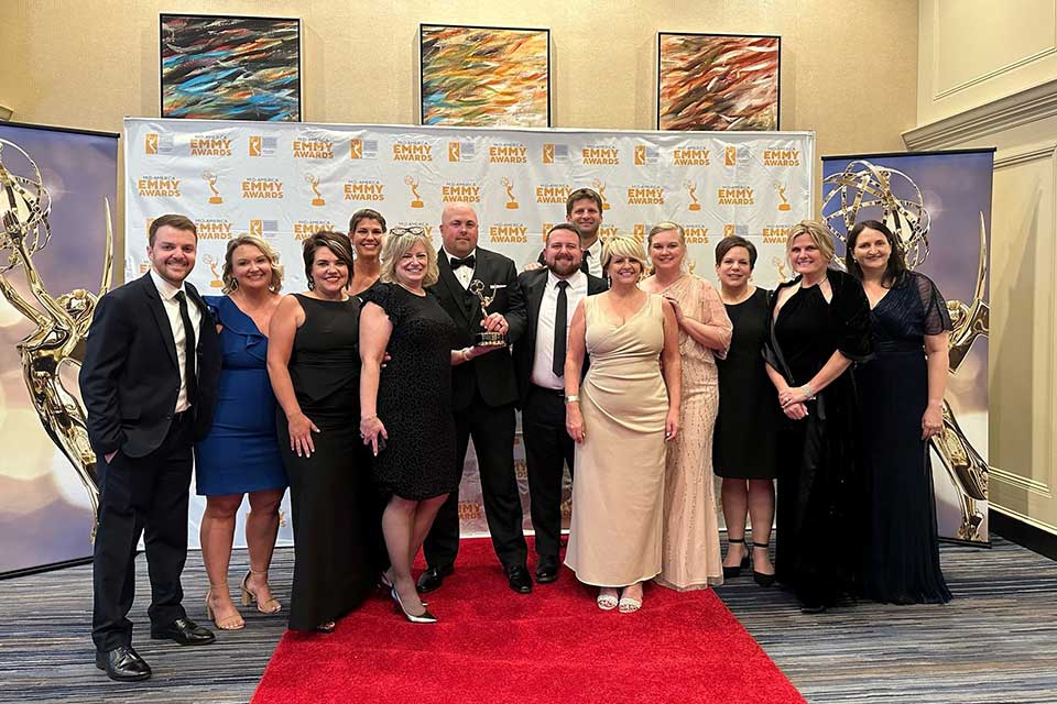 El equipo de la agencia de marketing de BAM y Tammy Robbins, directora regional sénior de Shriners Children's con el premio EMMY.