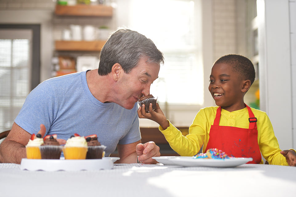 man and child baking cupcakes