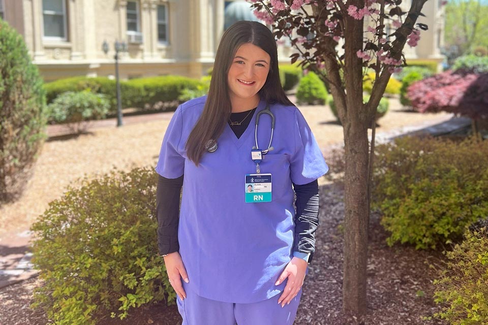 nurse Olivia outside wearing scrubs