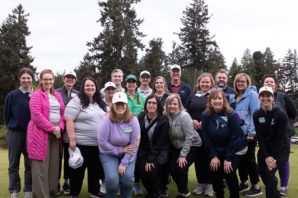 Grupo de miembros del personal de Spokane y Portland en un campo de golf