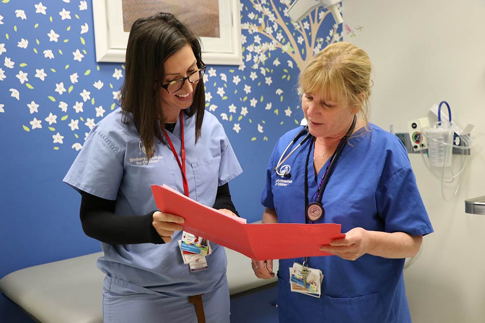 dos proveedoras de atención médica revisando papeles