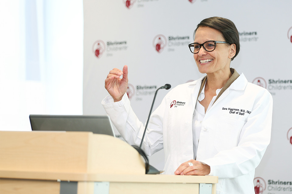 A physician speaking behind a podium.