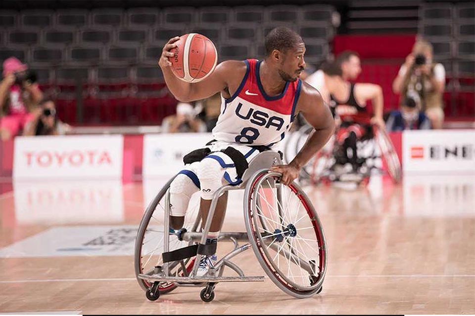 Brian in wheelchair dribbling basketball on court