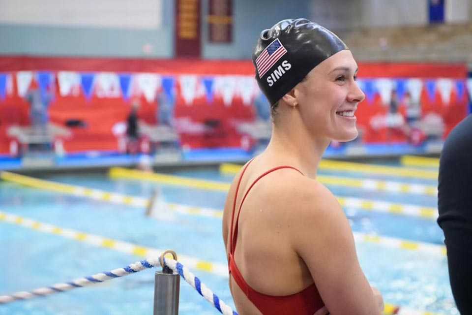 Natalie au bord de la piscine, portant un maillot de bain et une casquette