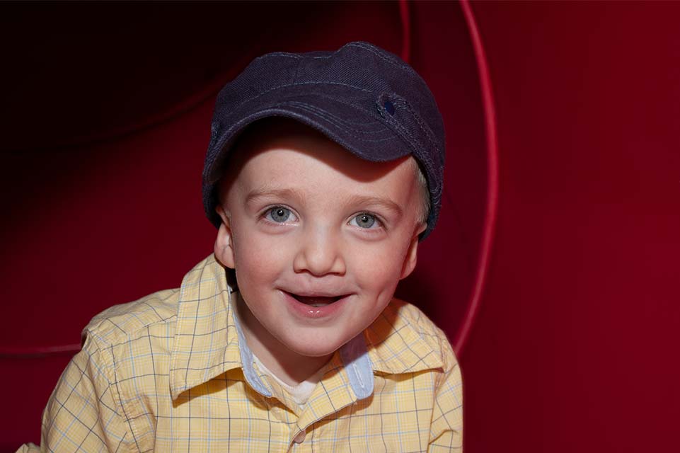 jeune garçon avec chandail jaune et chapeau bleu