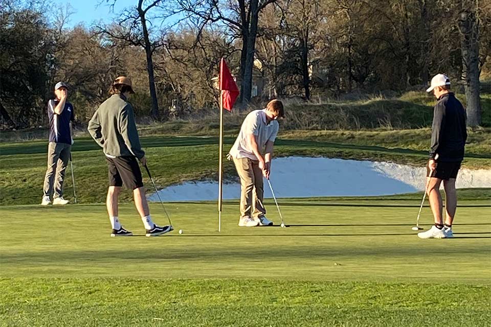 Sammy jouant au golf avec trois spectateurs