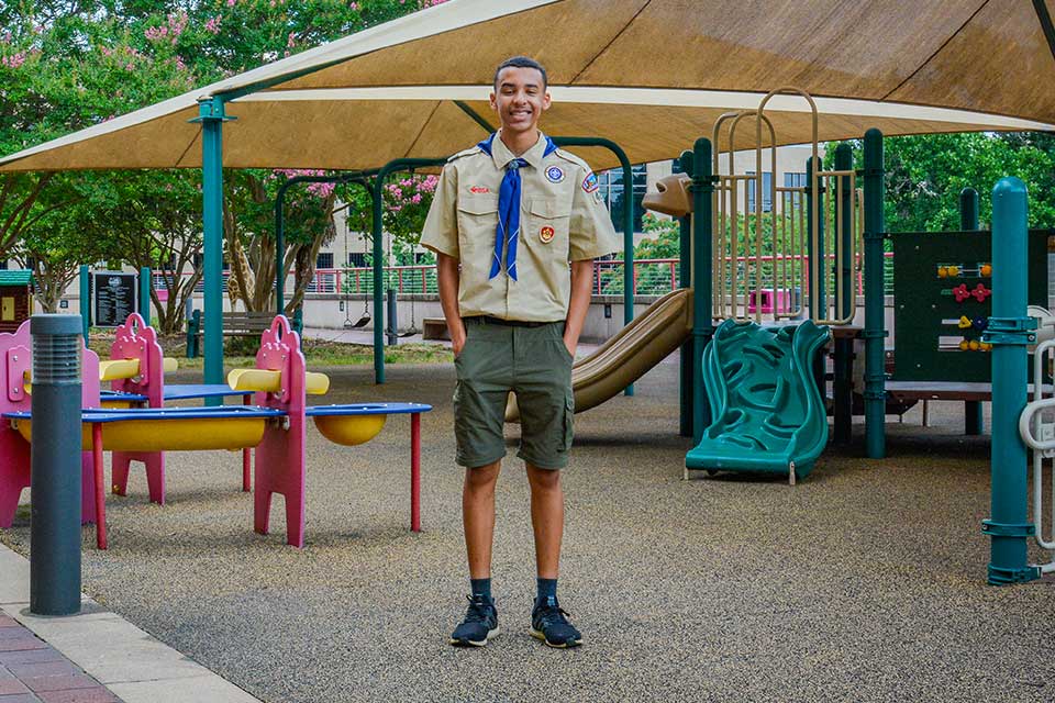 Shane de pie en el patio de recreo