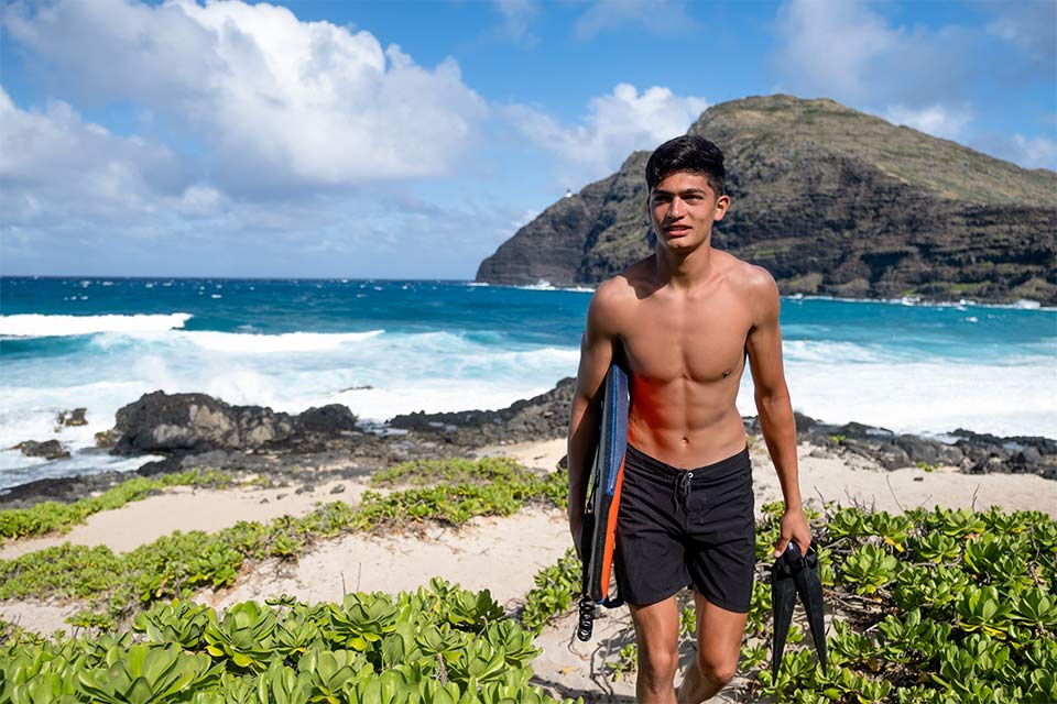 Hekili marchant sur la plage avec planche