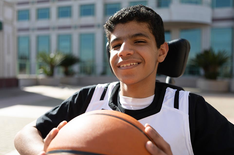 Mohammed souriant avec un ballon de basket