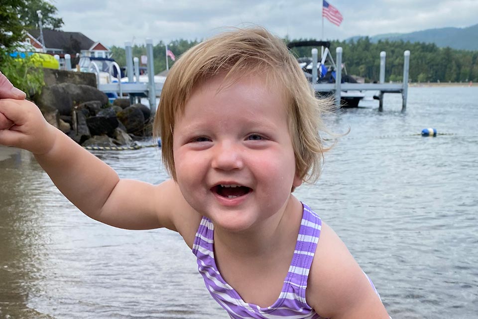 Grace with a huge smile on her face outdoors by waterway