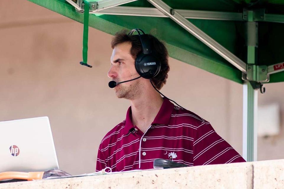 Graham sitting at microphone during sporting event