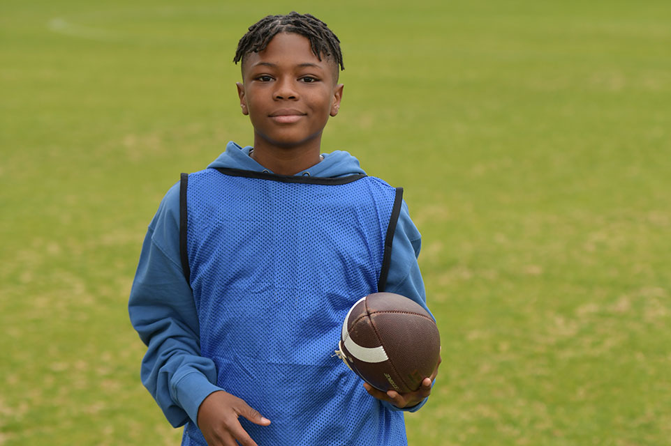 Parker holding a football, outside