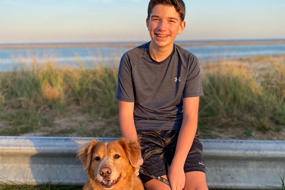 Sawyer et chien de famille assis dehors près de la plage