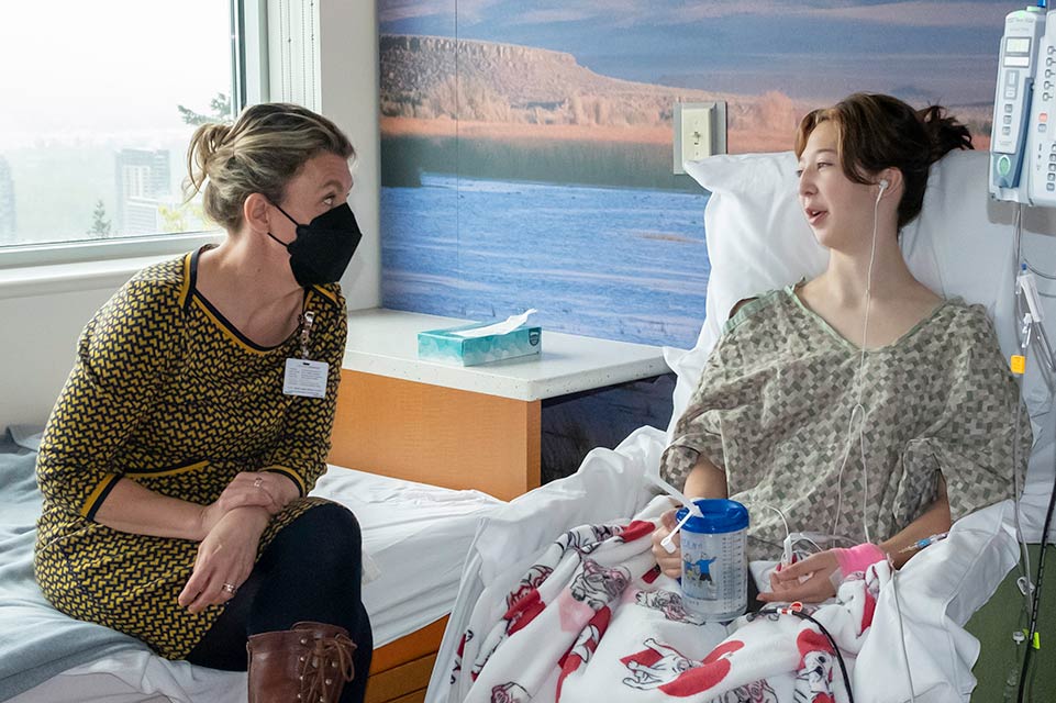 Médico hablando con un paciente en una cama del hospital