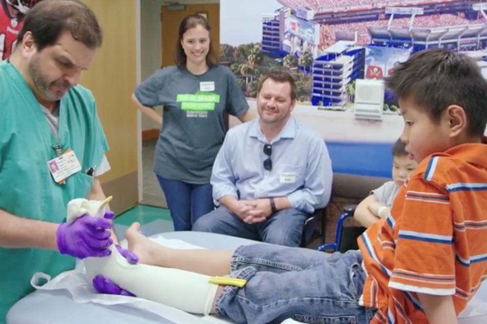 Little boy in cast being seen by doctor