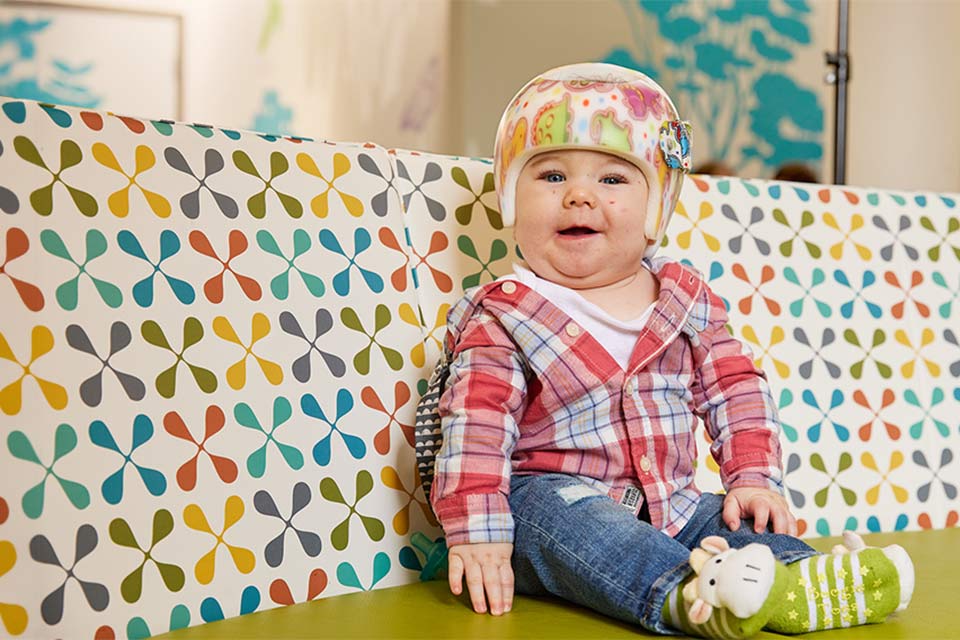 Patient in helmet smiling on seat