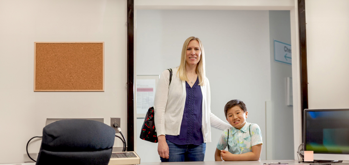 Male patient with his mother at desk