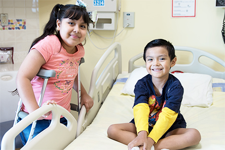 Niño y niña con muletas sonriendo 