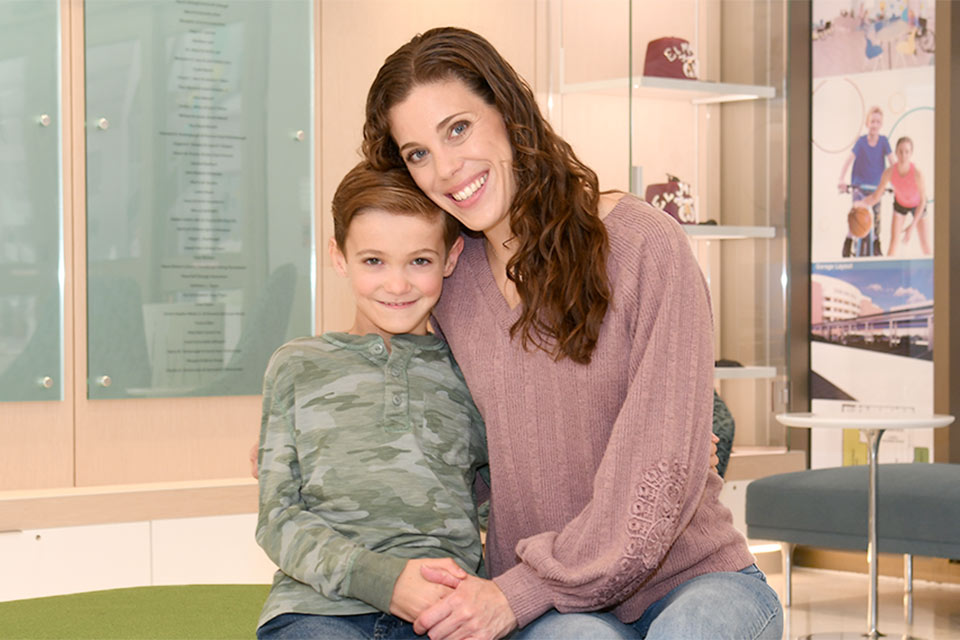 Male patient sitting and smiling with mother