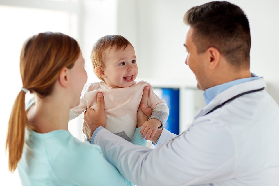 bebé feliz con la madre y el médico