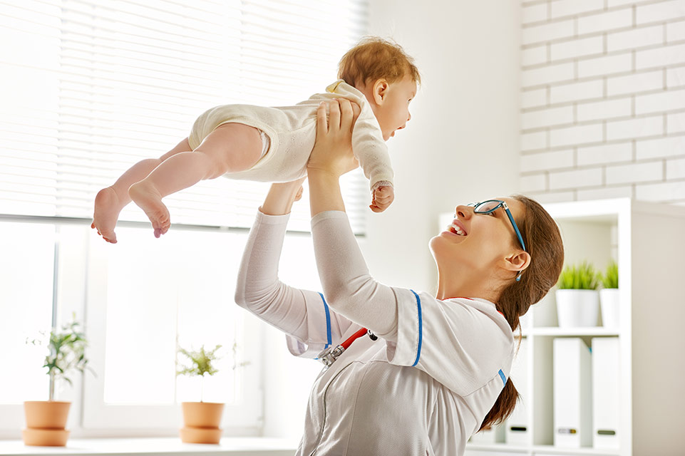 physician holding baby in the air